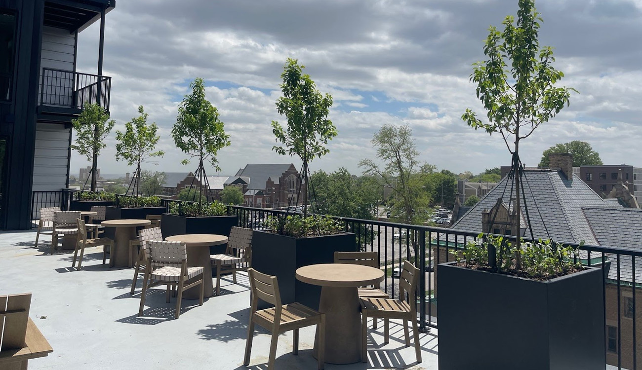 Rooftop patio with trees and seating.