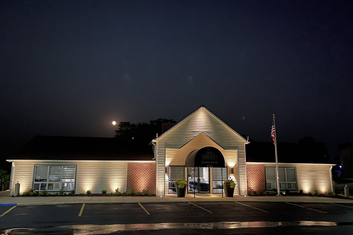 Commercial parking lot lighting illuminating an office building entrance for improved safety and nighttime visibility.
