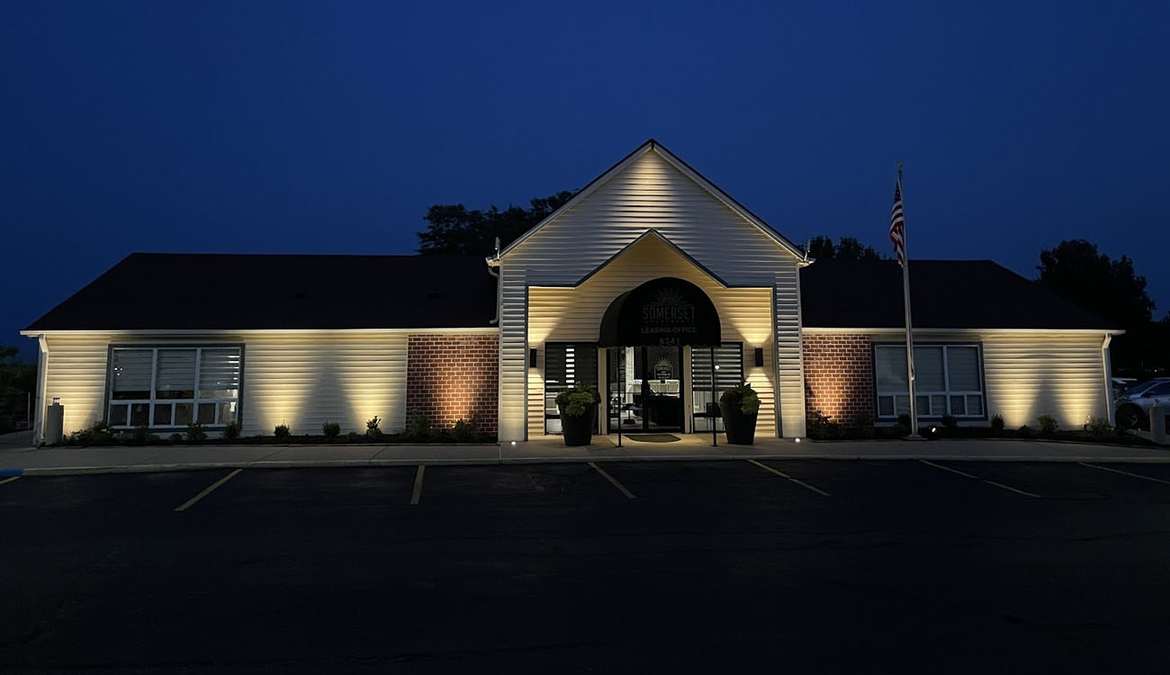 Evenly distributed commercial parking lot lighting around an office building to enhance security and curb appeal.