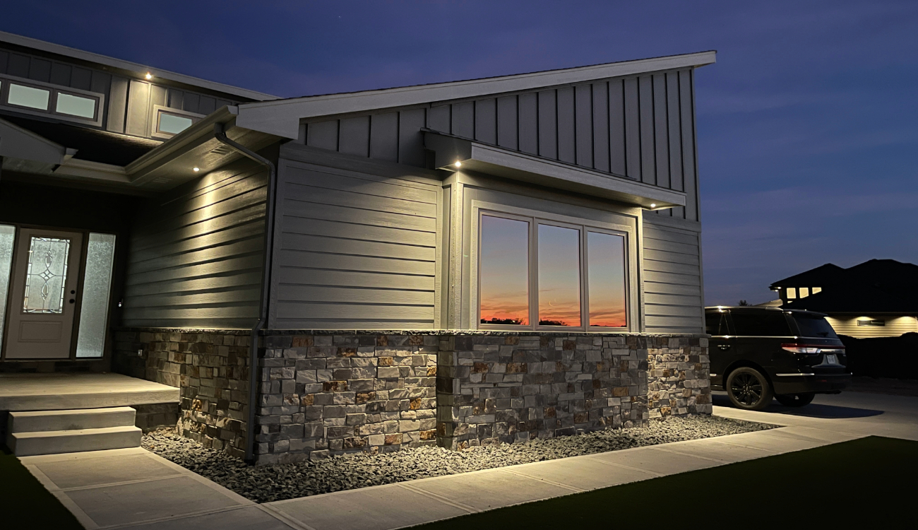 High-quality LED soffit lights illuminating a stone facade. We specialize in landscape lighting repair across the Midwest to fix flickering or broken outdoor fixtures.
